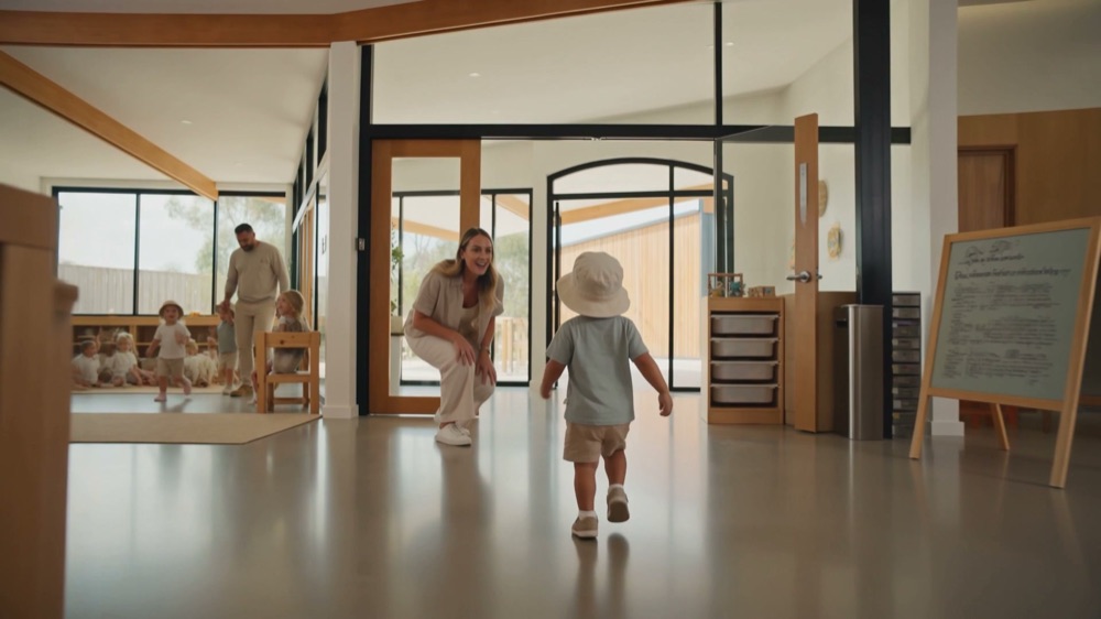 A toddler walking into the room straight toward the educator he knows